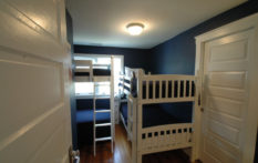 bedroom with two sets of bunk beds and navy blue wall in boston