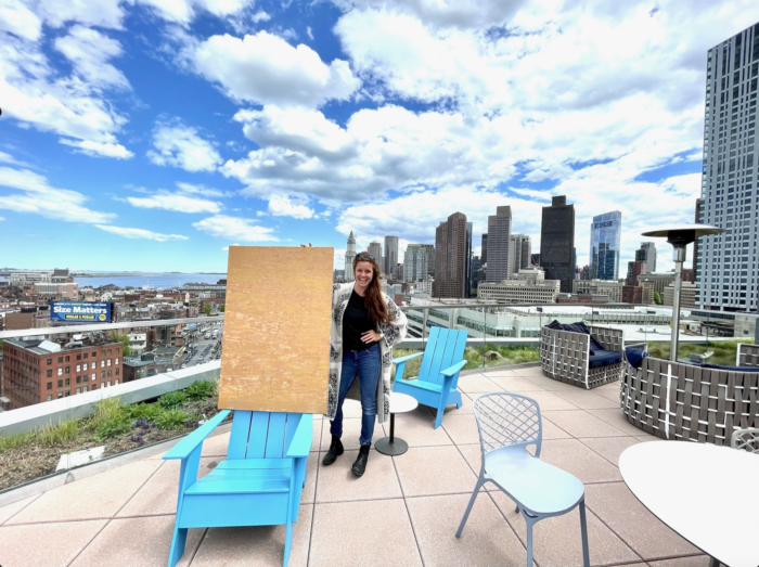 Sharin Schober posing with board and city of Boston in background