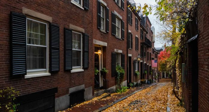 alleyway between buildings in newton ma with fall leaves on ground